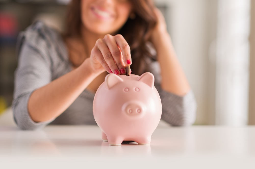 Woman putting money in a piggy bank