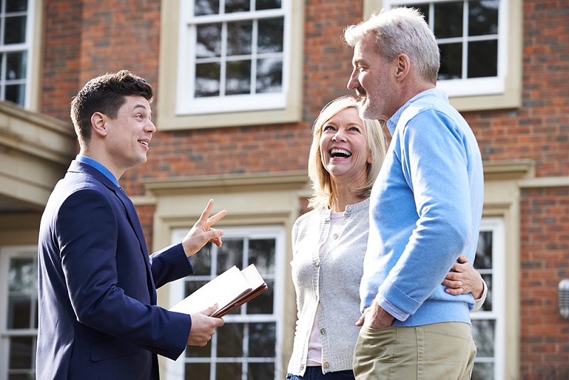 older couple talking to younger real estate agent